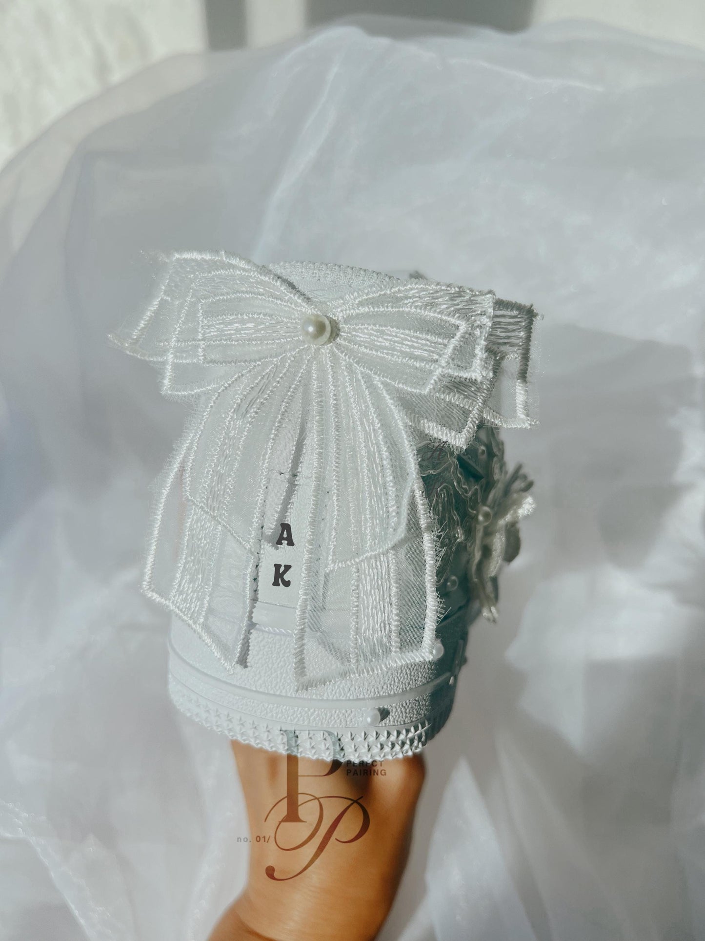 Back view of hand embroidered white bridal sneakers featuring an elegant bow detail, designed as custom wedding shoes for the bride.