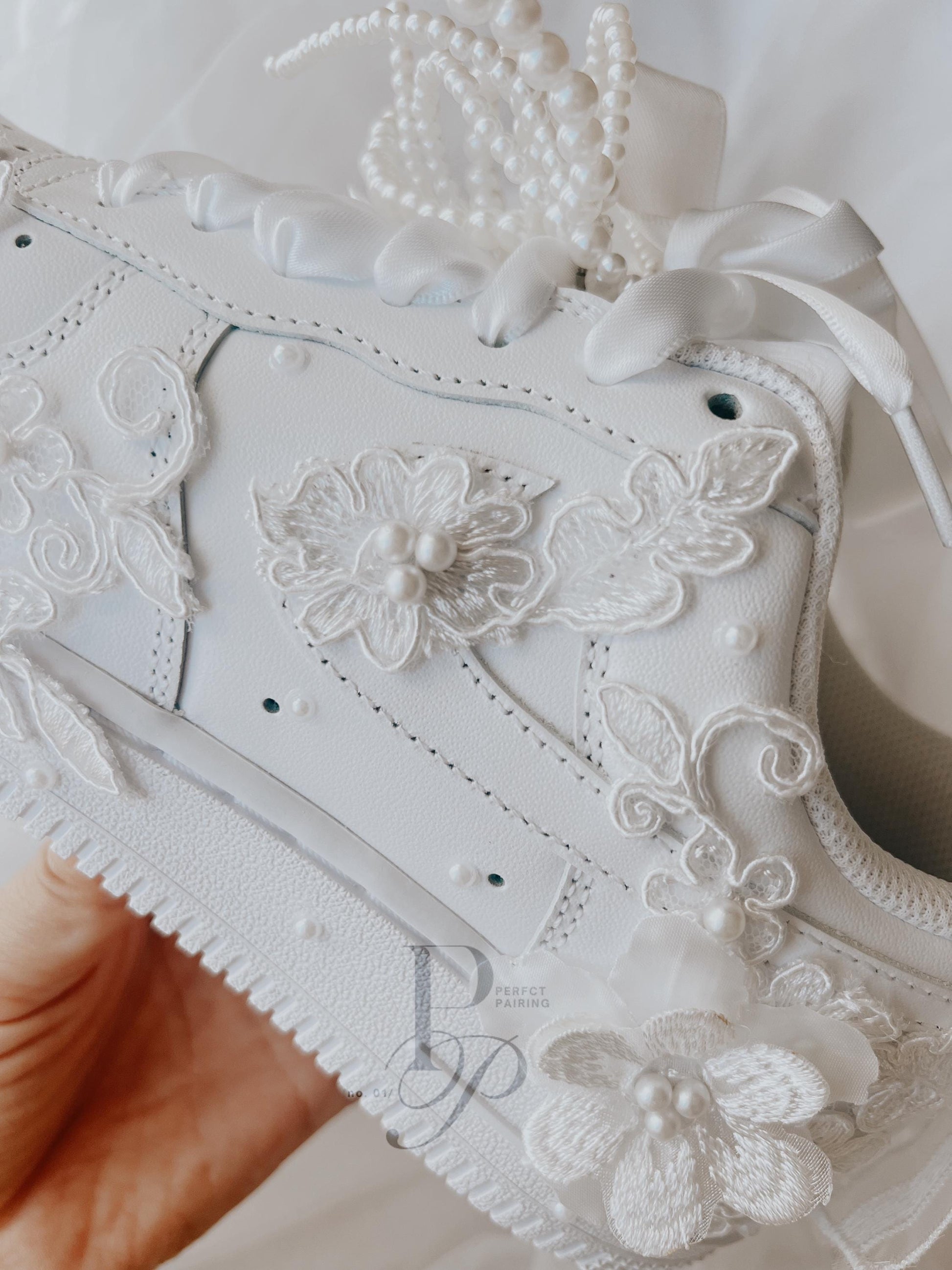 Detailed close-up of hand embroidery on bridal wedding sneakers, highlighting artisan stitching and elegant design.