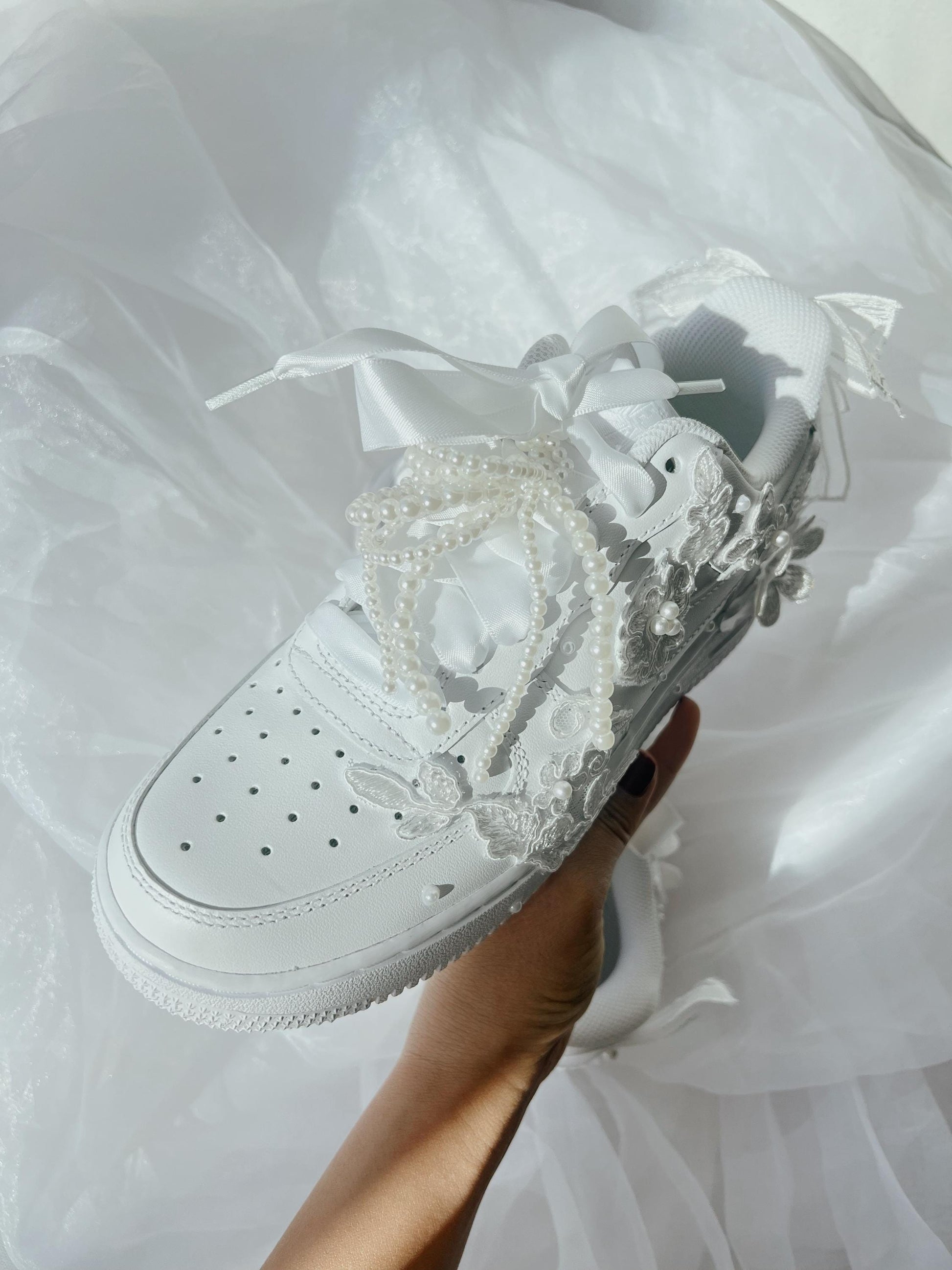 Removable pearl bow shoe accessory designed to add a soft, elegant bridal touch to wedding sneakers.