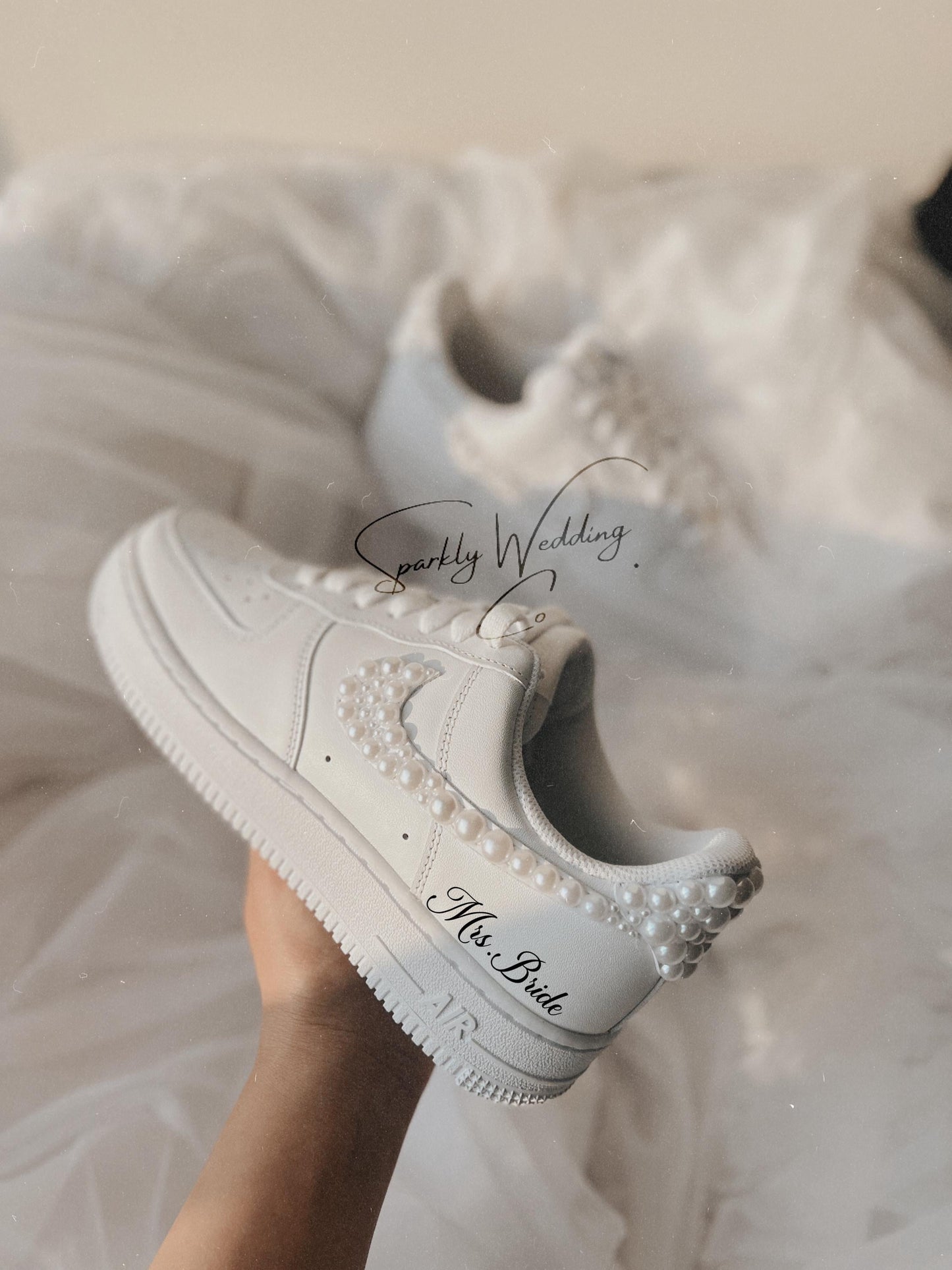 Close-up of custom pearl wedding sneakers showing pearls on the swoosh for bride
