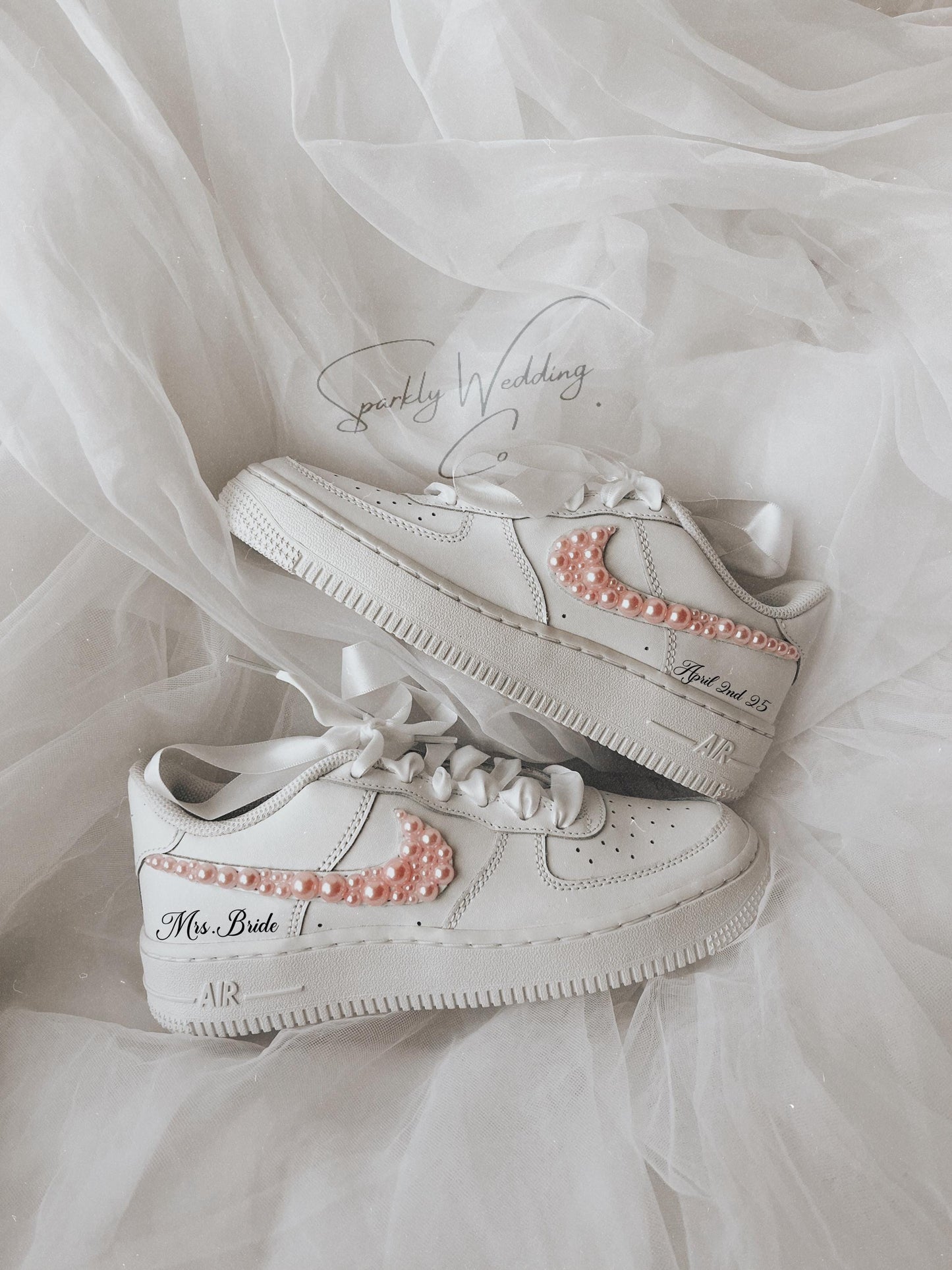 Side view of white bridal sneakers featuring soft pink pearl accents for a wedding look
