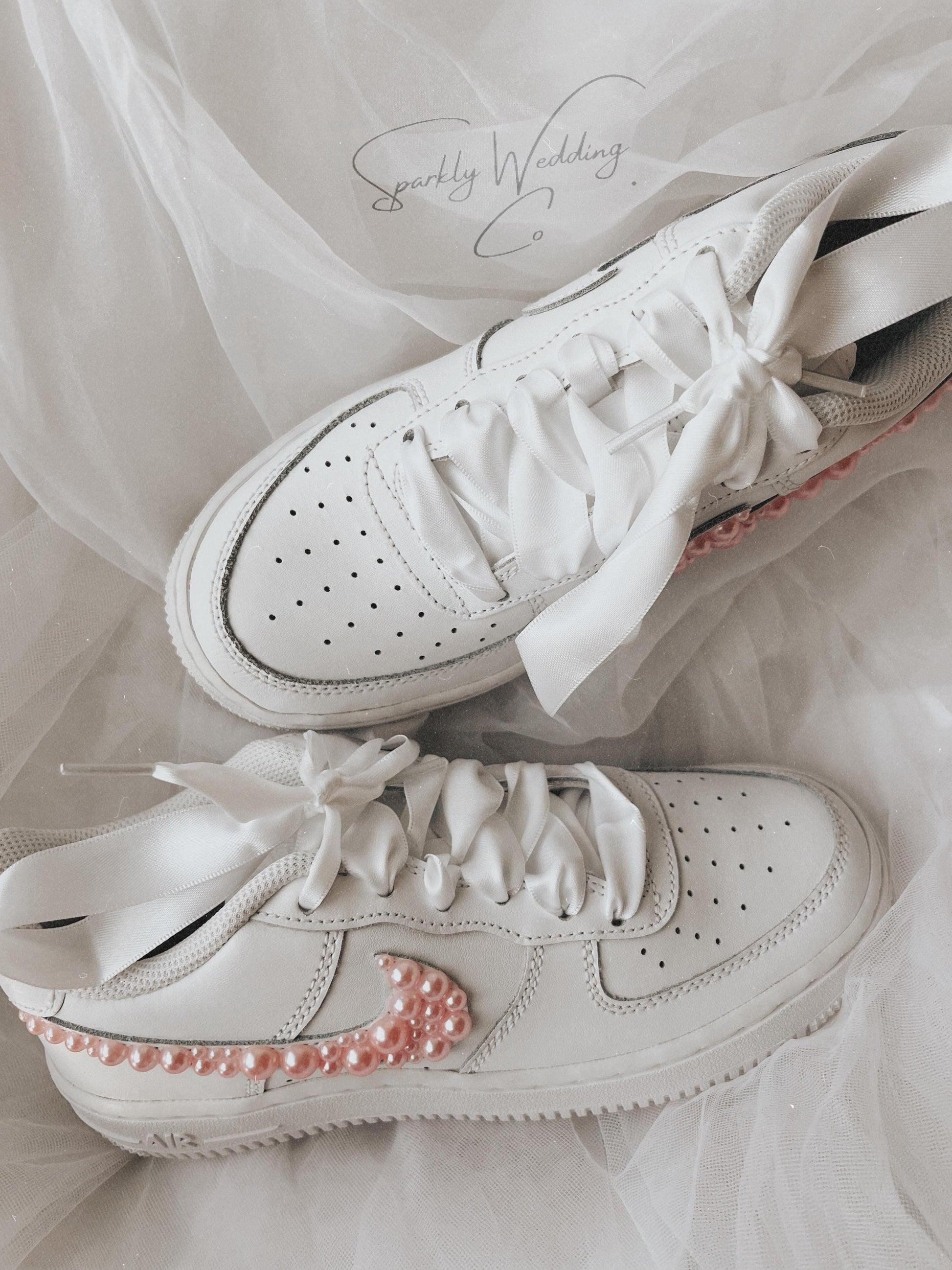 Flat lay of pink pearl bridal sneakers styled for wedding day and reception wear
