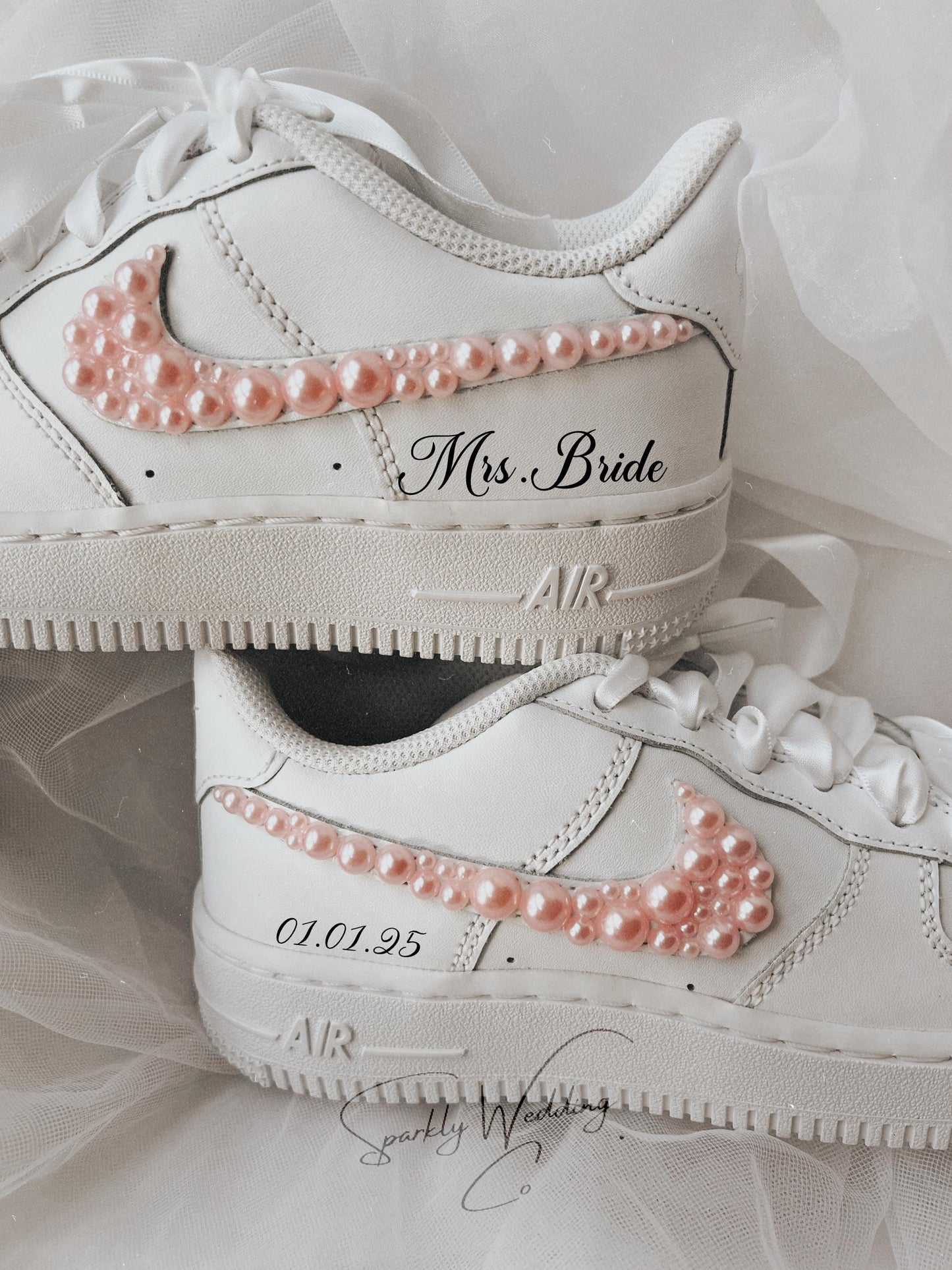 Close-up of pink pearl embellishments on the outer swoosh of bridal wedding sneakers
